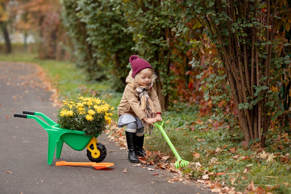 A young girl gardening with a wheelbarrow full of yellow flowers in an autumn setting.